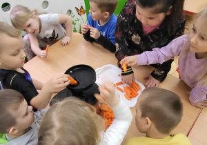 Dzieci wkładają warzywa do sokowirówki
