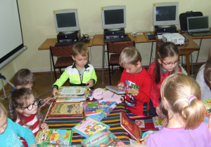 Dzieci oglądają nietypowe książki.