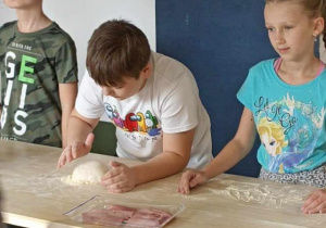 dzieci posypują mąką ciasto