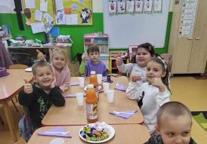 dzieci z kciukami do góry podczas poczęstunku