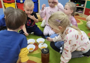 Dzieci jedzą przysmak misia - miód ciąg dalszy