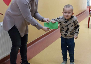 Dziecko odbiera kartkę walentynkowa z życzeniami