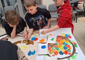 Chłopcy malują farbami impresje wielkanocne
