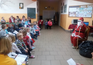 Mikołaj siedzi przed dziećmi