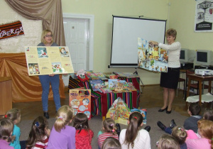 Bibliotekarki pokazują dzieciom plansze o książkach.
