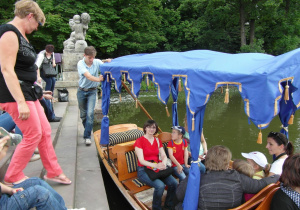 Uczestnicy wycieczki siedzą w łodzi w Łazienkach Królewskich