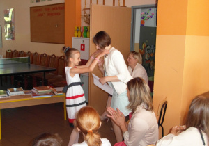 uczennica zawiesza medal na szyi Dyrektor szkoły Ewy Bolarczyk