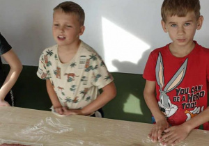 dzieci sprawdzają stan rozwałkowania ciasta