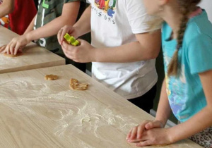 dzieci wykrawają ciasto różnymi foremkami