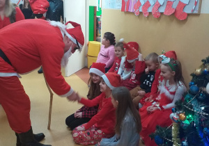 Dzieci podają rękę Mikołajowi